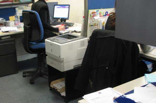 Imprimante située entre deux bureaux ouverts